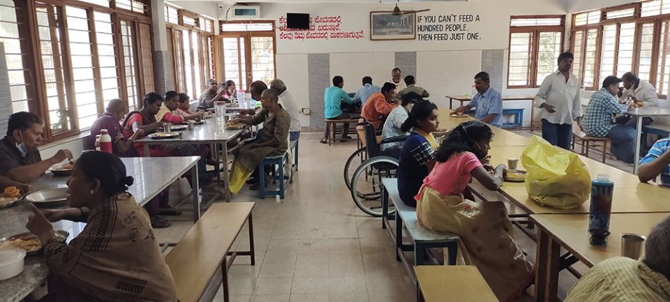 The residents of Sumanahalli share lunch with the sisters, volunteers and staff. On the day GSR visited Sumanahalli, the food was served by a Hindu family in a celebration marking their wedding anniversary. (Thomas Scaria)