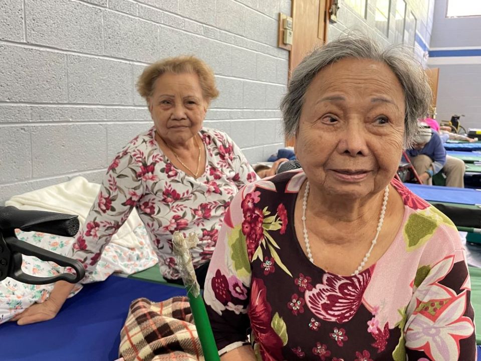 Pham This Sang, 91, and her sister Pham This Menh, 81, were resting in an air-conditioned saloon for seniors. Small beds were set up for people to rest.  (Peter Tran)
