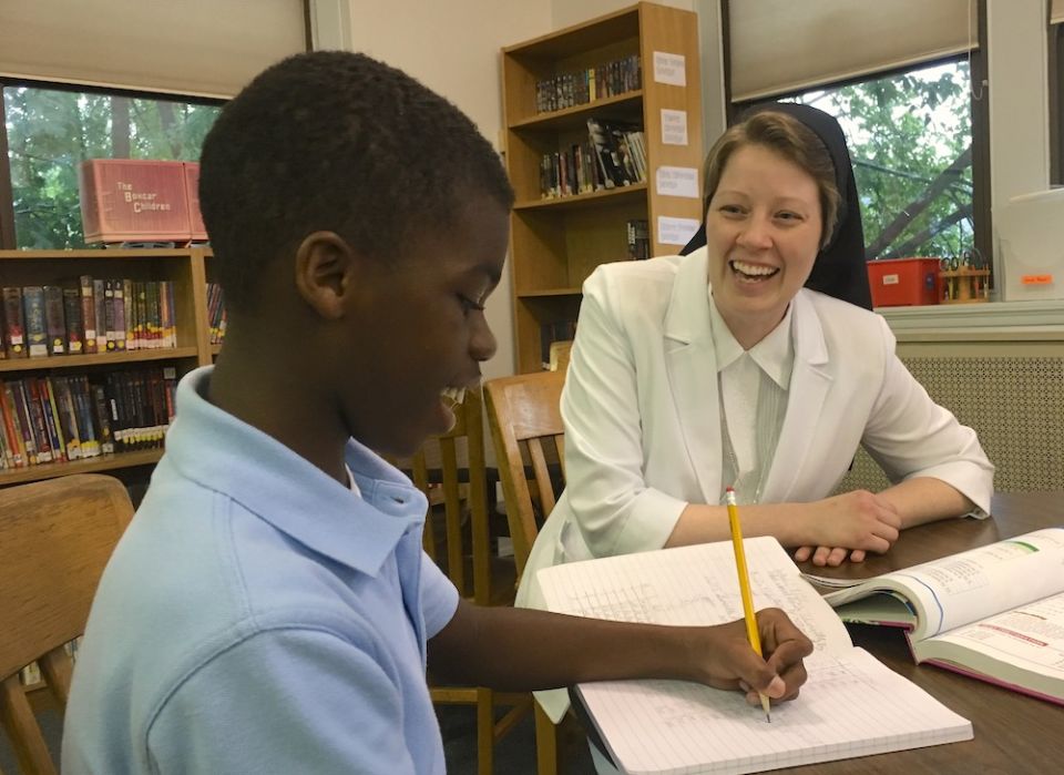 Before the pandemic, Immaculate Heart of Mary Sr. Danielle Truex enjoys a moment of shared laughter with one of her students at Sacred Heart School in Lancaster, Pennsylvania, where she is the principal. (Provided photo)