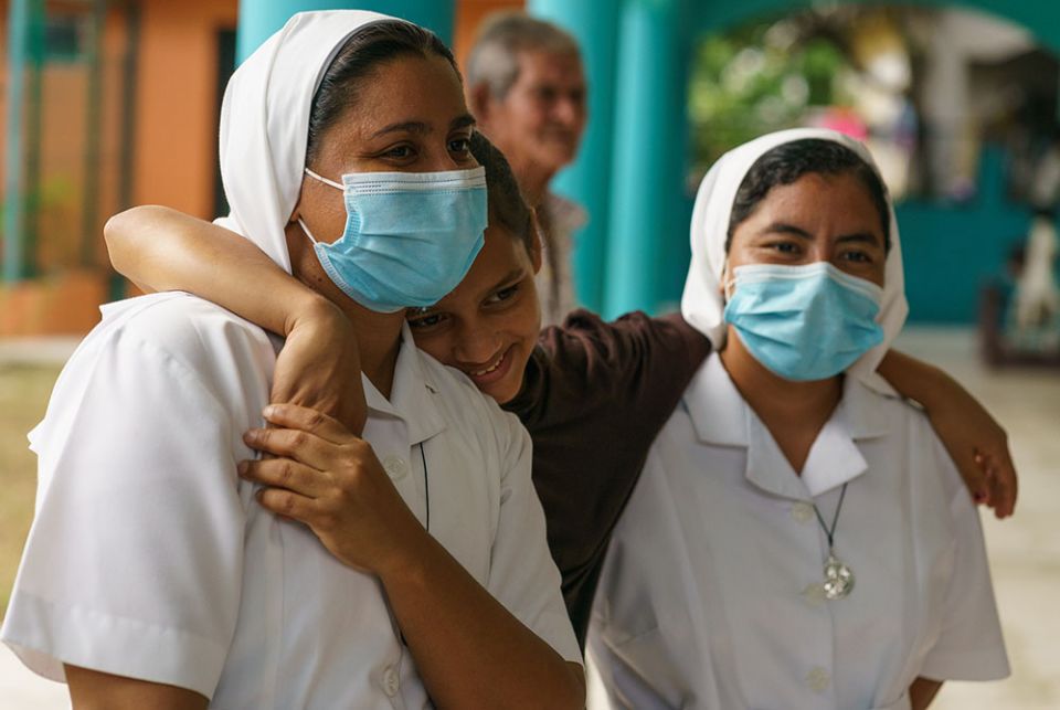 Srs. Jessica Karina Lemus Sánchez and Ana Felipa Olvera Pérez of the Missionaries of Mary Immaculate in Choloma, Honduras, with a young girl whose displaced family is living in the mission's nursery school rooms. (Gregg Brekke) Srs. Jessica Karina Lemus Sánchez and Ana Felipa Olvera Pérez of the Missionaries of Mary Immaculate in Choloma, Honduras, with a young girl whose displaced family is living in the mission's nursery school rooms. (Gregg Brekke)