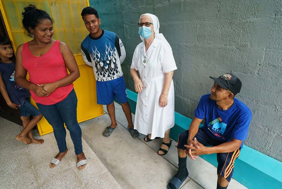 Sr. María Luisa Canencia Garcia of the Missionaries of Mary Immaculate in Choloma, Honduras, is pictured with a family living in the rooms of the mission's nursery school. (Gregg Brekke)