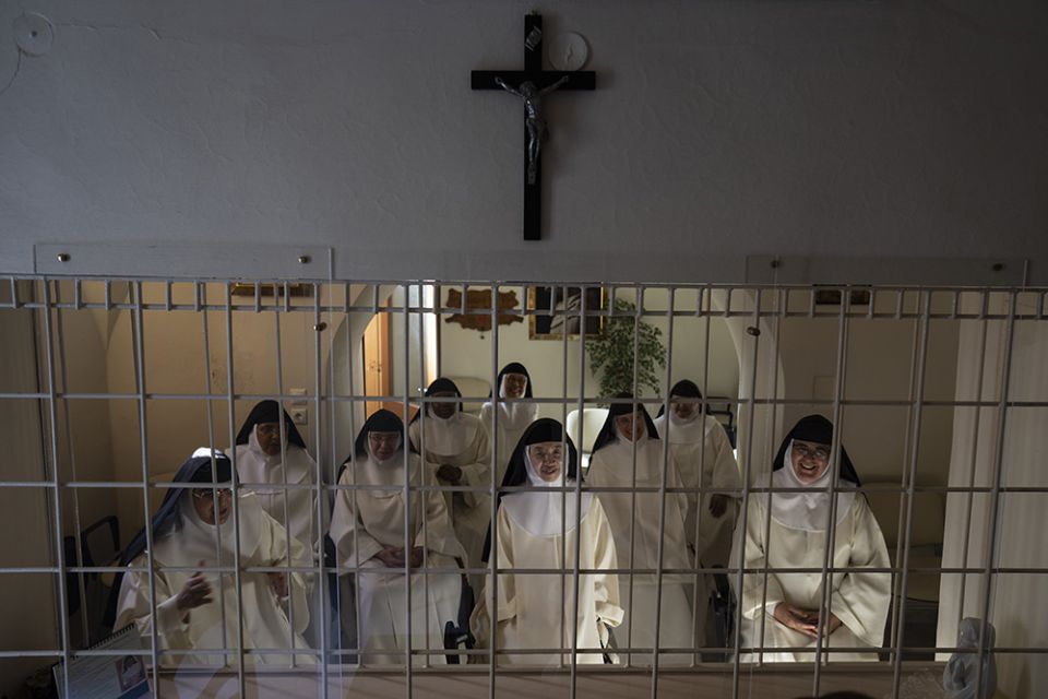 Nuns speak to journalists from behind a white iron grille in the parlor of the Monastery of St. Catherine on the Greek island of Santorini June 14.