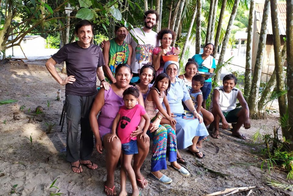 Sr. Lúcia Vieira Gonçalves of the Daughters of St. Mary of Providence, seated in habit, on an August 2020 visit to St. Jorge's and other communities along the riverbeds of the Amazon River and its tributaries, one of the main jobs of religious women in th