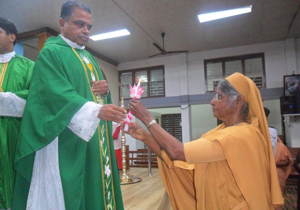 Dinasevanasabha (Servants of the Poor) Sr. Balini Chittattukara receives a candle from Fr. James Culas, pioneer of the parish renewal program in the Latin Archdiocese of Trivandrum, as a symbol of commissioning her for Home Mission (Balini Chittattukara)