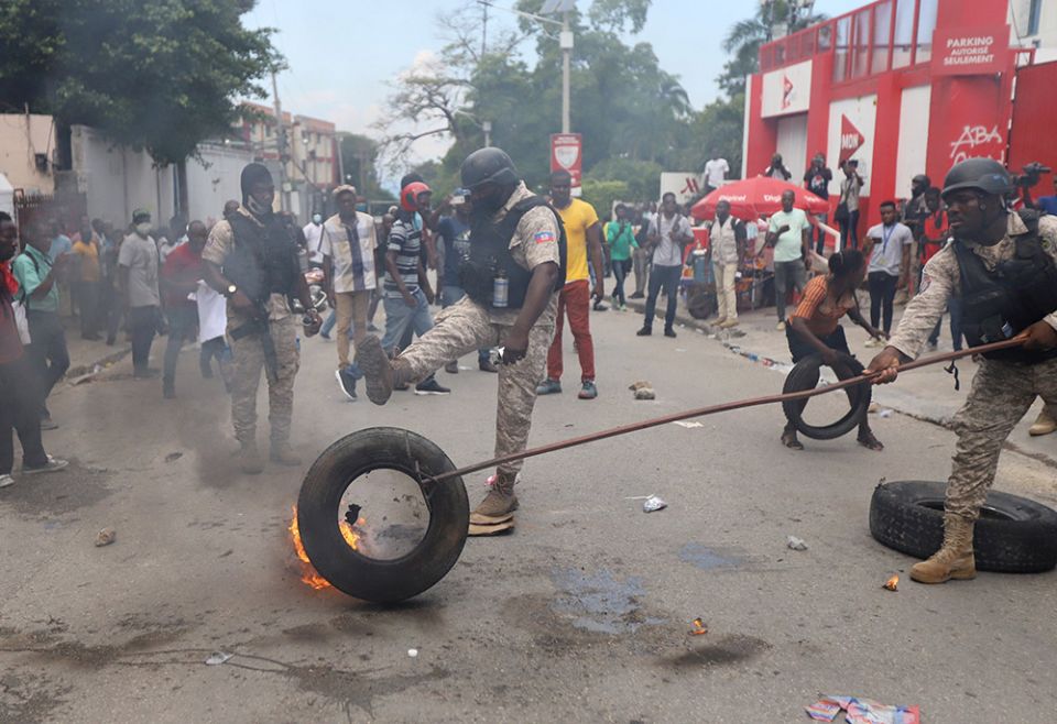 Police in Port-au-Prince, Haiti, remove a burning tire Oct. 18, 2021, as people mount a nationwide strike to protest a growing wave of kidnappings. (CNS/Reuters/Ralph Tedy Erol) Police in Port-au-Prince, Haiti, remove a burning tire Oct. 18, 2021, as people mount a nationwide strike to protest a growing wave of kidnappings. (CNS/Reuters/Ralph Tedy Erol)