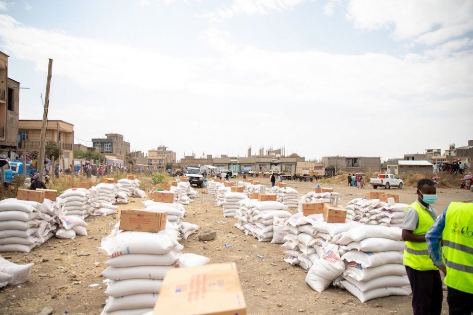 Rows of white bags of food stretching into the distance in a sandy town