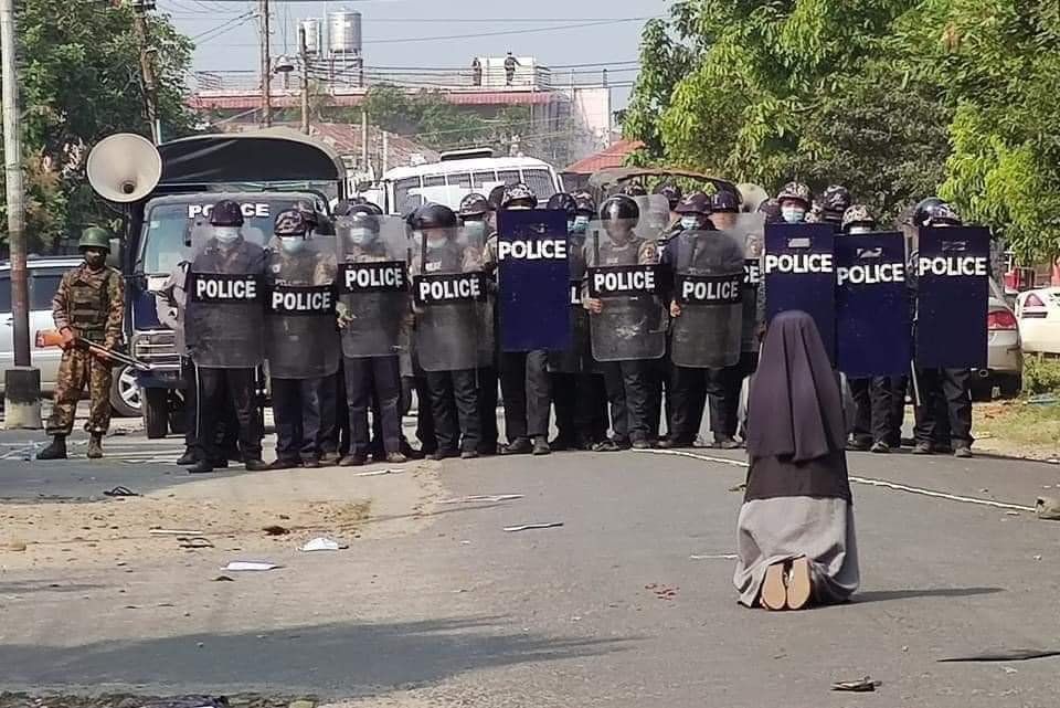 Sr. Ann Nu Thawng, a member of the Sisters of St. Francis Xavier, kneels in front of police and soldiers during an anti-coup protest Feb. 28 in Myitkyina, Myanmar. (CNS/Courtesy of the Myitkyina News Journal)