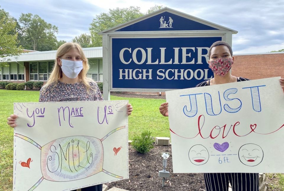 Maddie Thompson, left, and Madison Thomas, a former Good Shepherd Volunteer, pose with their welcome signs outside of Collier High School in Wickatunk, New Jersey. (Christina Hardebeck)