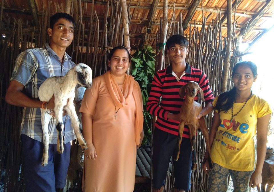 Sr. Crina Cardozo of the Sisters of Holy Family of Nazareth with Dhangar tribe siblings showing their young goats in Fullamol village in Goa, western India (Lissy Maruthanakuzhy)