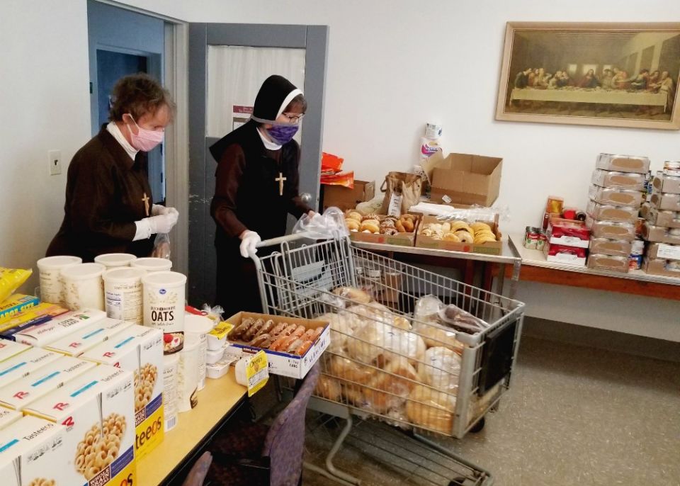 Deo Gratias Ministries Detroit co-directors Sr. Shelley Marie Jeffrey, left, and Sr. Felicity Marie Madigan sort and organize supplies in the food pantry. (Courtesy of the Felician Sisters of North America)