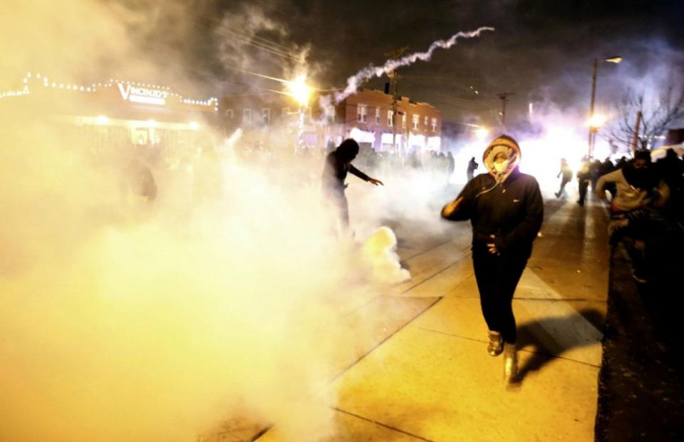 Protesters run from a cloud of tear gas Nov. 24, 2014, after a grand jury returned no indictment in the Aug. 9, 2014, shooting death of Michael Brown.