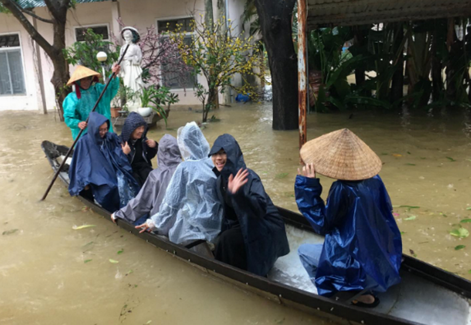 Daughters of Mary of the Immaculate Conception nuns take a boat to visit people in Con Hen islet in Huong River on Oct. 25. (Joachim Pham)