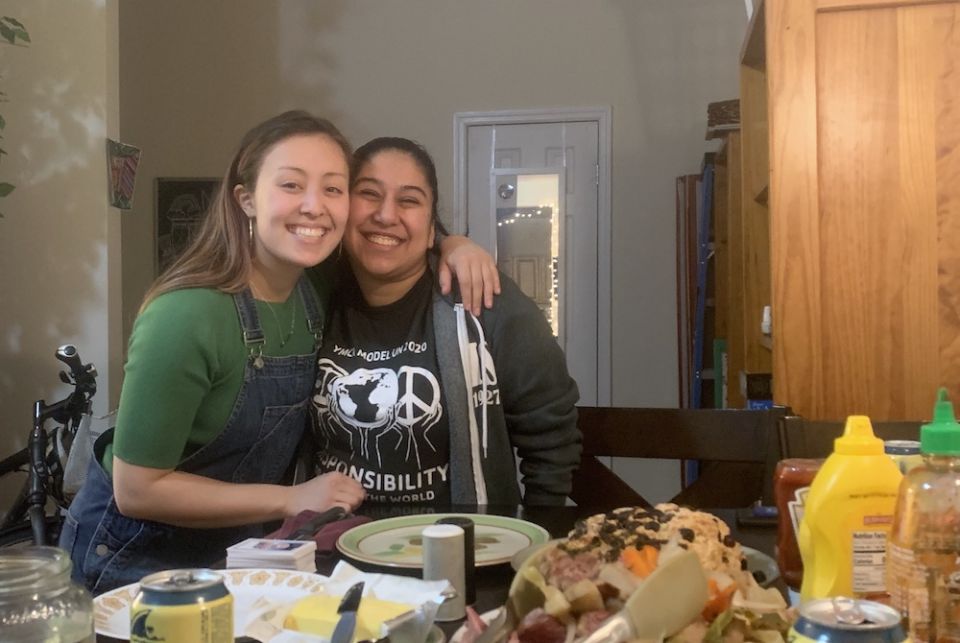 Two young women smiling in a kitchen