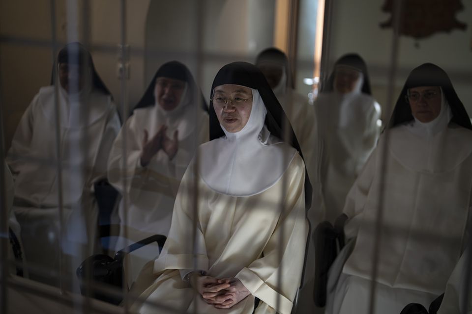 Sister María de la Trinidad, center, and other nuns speak to journalists from behind a white iron grille in the parlor of the Monastery of St. Catherine on the Greek island of Santorini June 14. (AP/Petros Giannakouris)