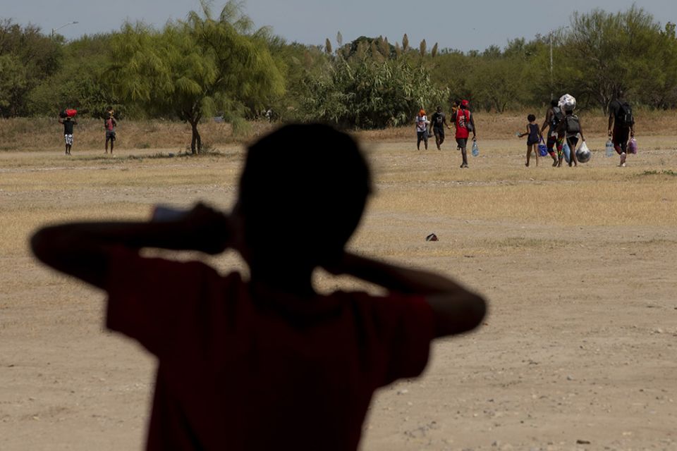 A boy watches other Haitians walk toward the Rio Grande, where many crossed into Del Rio, Texas, from an immigrant camp in Ciudad Acuña, Mexico, Sept. 22. (Nuri Vallbona)