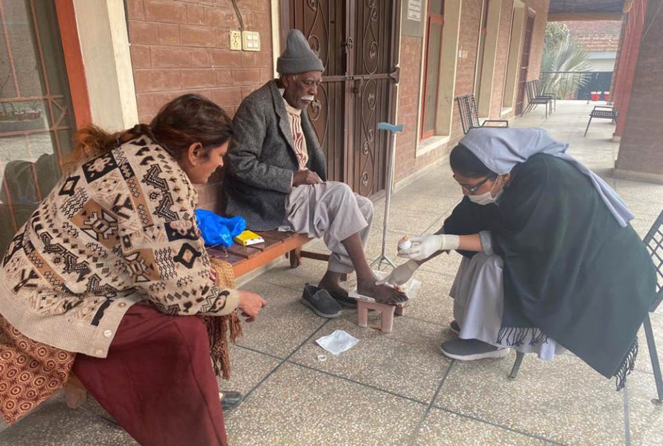 A Sister of Charity of Jesus and Mary tends to a man's wounds at Shakina Home for the Aged in Youhanabad, Lahore, Pakistan.  (Courtesy of Sabina Barkat)