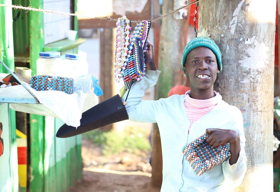 Mary Wanjiku, 26, displays one of her beaded products next to her shop in Limuru, a town in central Kenya. Wanjiku is a beneficiary of the Limuru Cheshire Home, a charitable institution for girls living with disabilities in Kenya. (Wycliff Oundo)