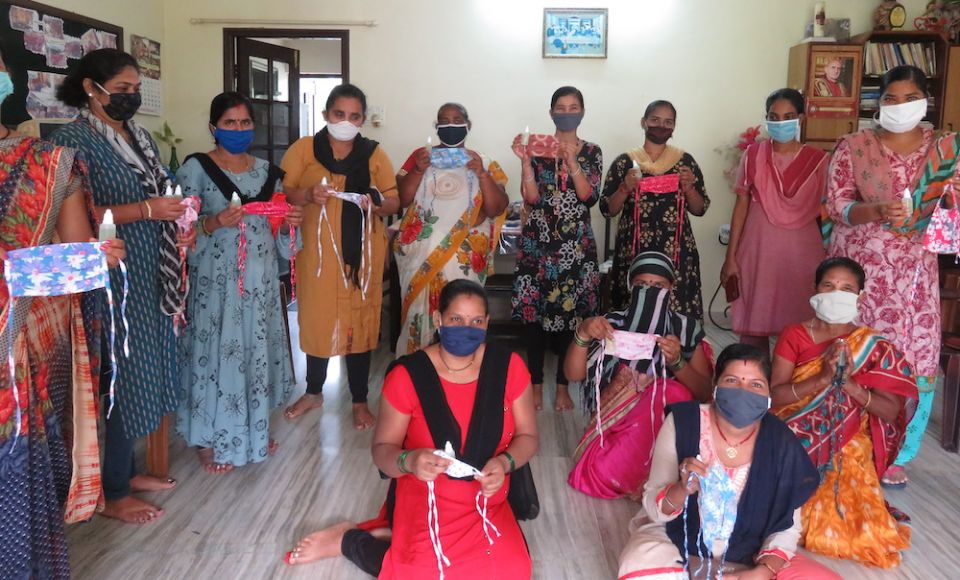 Migrant workers show off the masks they have sewn to sell as part of an income-generating program in Goa, India. (Provided photo)