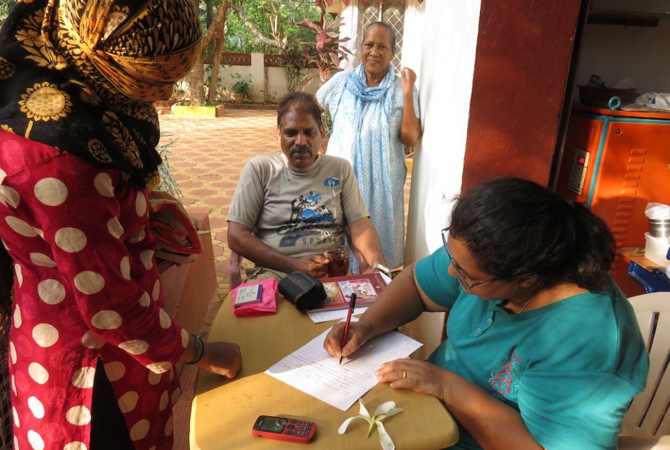 Sr. Marie Lou Barboza, standing in back, watches over as migrant workers register for a coronavirus awareness training program in Calangute, Goa, India. (Provided photo)