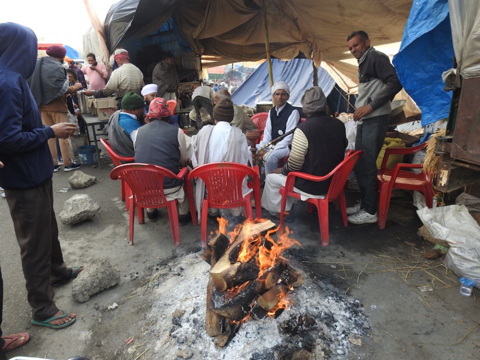 Farmers who are on strike in India at Delhi's Singhu border gather around a fire to keep warm. They are protesting three farm bills that were passed Parliament in September 2020. (Wikimedia Commons/Harvinder Chandigarh)