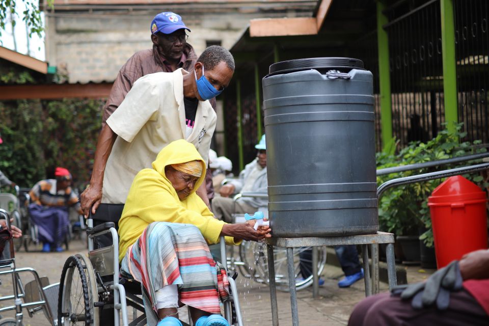 A staff member assists a resident at the Cheshire Home for the Elderly in the Kariobangi slum northeast of Nairobi, Kenya. The home is run by the Franciscan Missionary Sisters for Africa. (GSR photo/Doreen Ajiambo)
