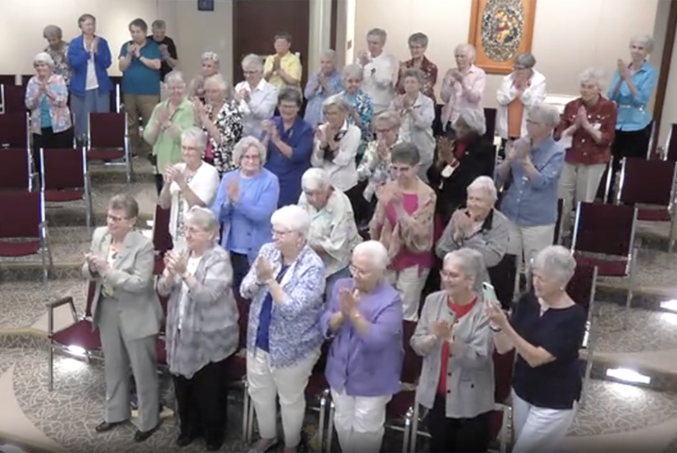 Sisters in the Adrian Dominican auditorium in Adrian, Michigan, give Dominican Sr. Elise García a standing ovation at the conclusion of her Aug. 11 presidential address to the Leadership Conference of Women Religious. (GSR screenshot)