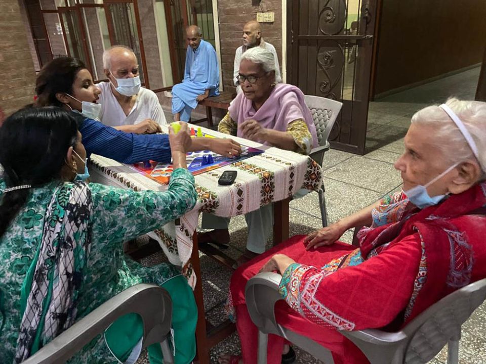 Residents of Shakina Home for the Aged in Youhanabad, Lahore, Pakistan, play Ludo, a strategic board game.  (Courtesy of Sabina Barkat)