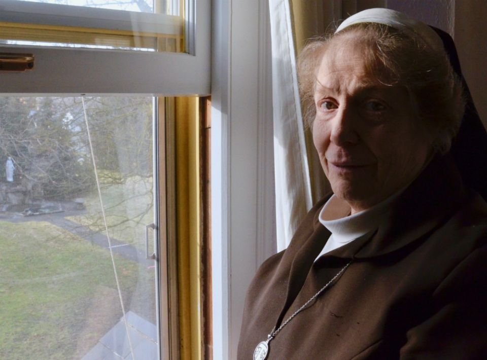 Sr. Marcia Kay LaCour, abbess of the Poor Clares in Spokane, Washington, at a window overlooking the grounds of the Monastery of St. Clare on Jan. 30 (GSR photo / Dan Stockman)