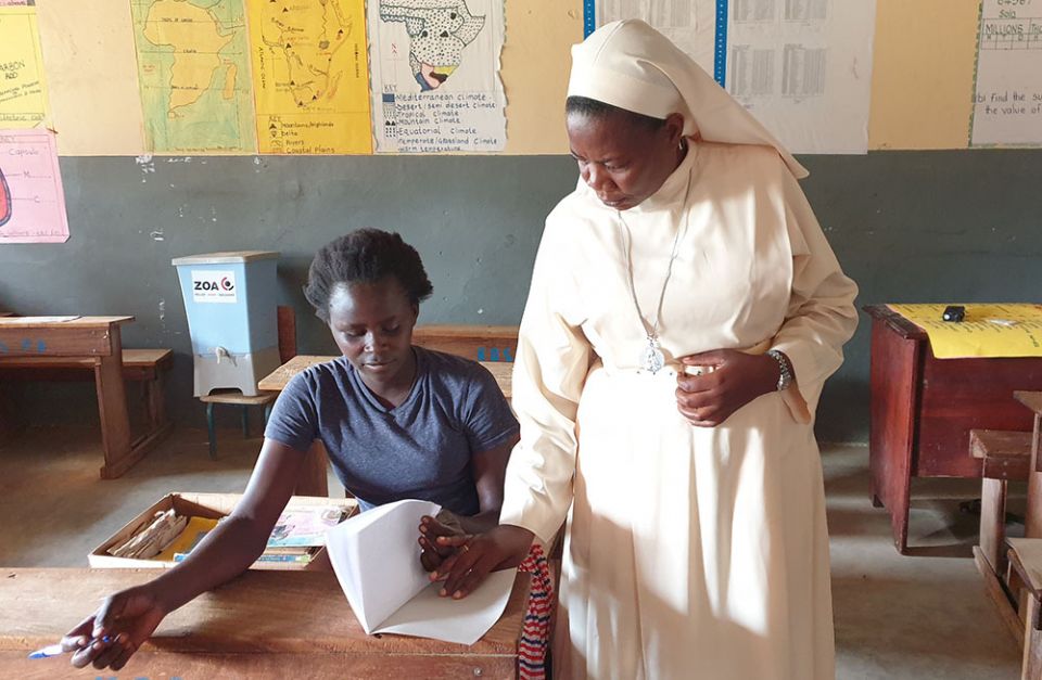Sr. Maria Proscovia Nantege of the Sisters of the Immaculate Heart of Mary Reparatrix-Ggogonya supervises one of the rescued girls in a Kalas Girls Primary School class in Amudat, northern Uganda. (Gerald Matembu)