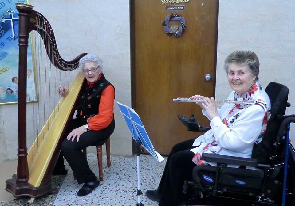 Dominican Sr. Mary Anna Euring, right, plays flute with Sr. Miriam Cecile Lenihan on the harp in 2016. Lenihan died last year. (Courtesy of Sr. Mary Anna Euring)