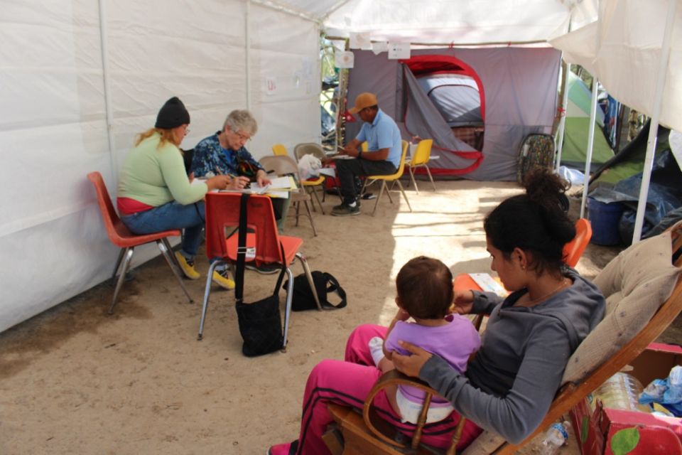 Sr. Mary Alice McCabe has struck up a friendship with Arsenio, the man with the baseball cap in the background, who is a Nicaraguan schoolteacher who has set up a small school in the camp under this tent. (GSR photo / Tracy L. Barnett)