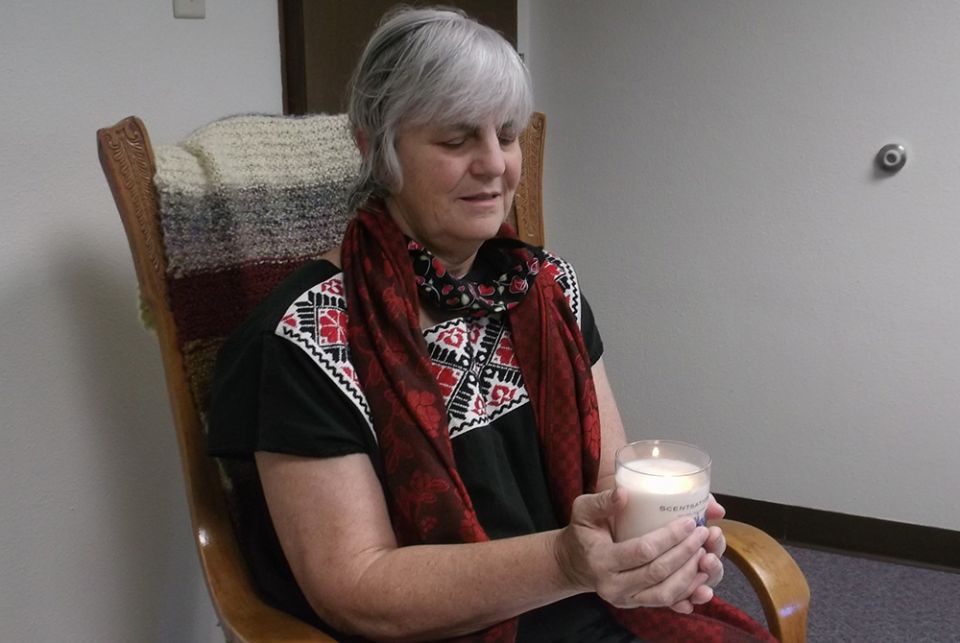 Franciscan Sr. Maureen Leach sits in contemplation with a candle from her location in Dubuque, Iowa, as part of her participation in the 2020 virtual assembly of the Leadership Conference of Women Religious. (Courtesy of LCWR)