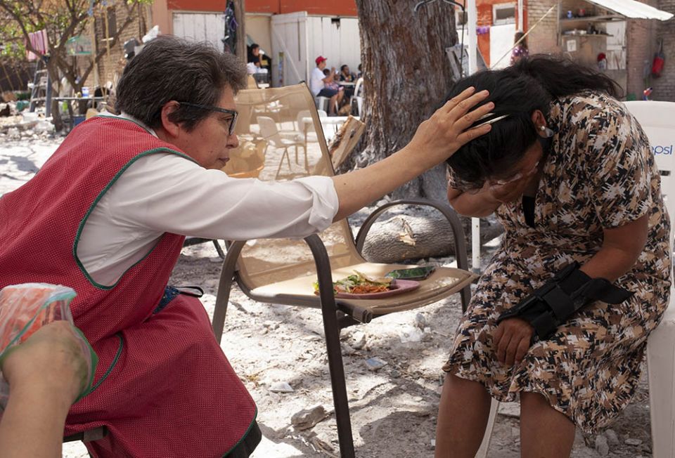 Sr. Mercedes Castillo prays over a Peruvian woman who only wanted to be known by the initials A.N. in the courtyard of the El Buen Samaritano shelter in Nuevo Laredo, Mexico, on March 27. (Nuri Vallbona) Sr. Mercedes Castillo prays over a Peruvian woman who only wanted to be known by the initials A.N. in the courtyard of the El Buen Samaritano shelter in Nuevo Laredo, Mexico, on March 27. (Nuri Vallbona)