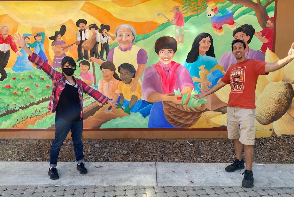 Notre Dame Mission Volunteers-AmeriCorps Jennifer Castro-Lara, left, and Samuel McCoy pose in October by a mural at the St. Francis Center in Redwood City, California