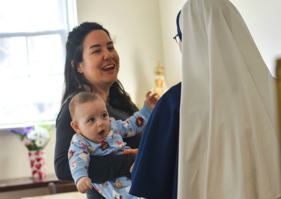 A Sister of Life talks to a mother and baby. The Sisters of Life invite pregnant women to live with them at their convent during their pregnancies. (Courtesy of the Sisters of Life)