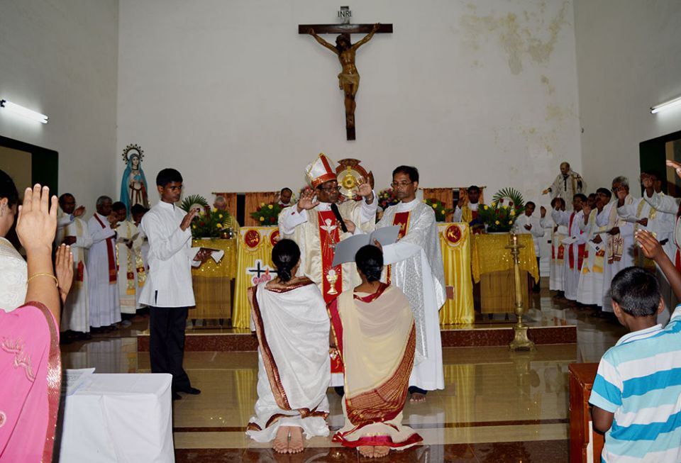 Srs. Sujata Jena and Goretti Nayak receive solemn blessings from Archbishop John Barua during their final vows as members of the Congregation of the Sacred Hearts of Jesus and Mary on Oct. 11, 2014, at St. Vincent Catholic Church in Bhubaneswar, Odisha