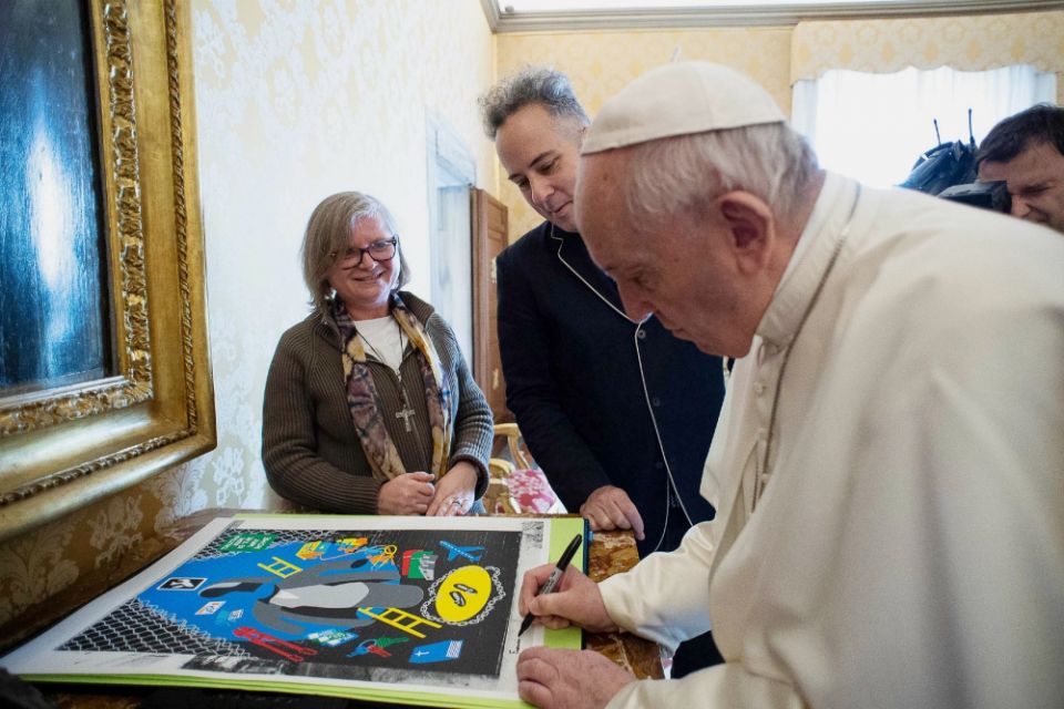 Comboni Missionary Sr. Gabriella Bottani, international coordinator of Talitha Kum, and artist Stephen Powers, also known as ESPO, watch Pope Francis sign a print of Powers' art. (Provided photo)