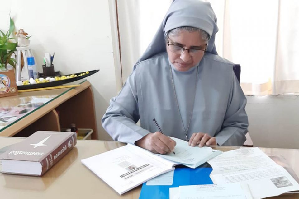 Sr. Tessy Kodiyil of the Congregation of the Holy Family writes letters to relatives of accident victims in her office at Aswas in Changampuzha Nagar, Kochi, in the southern Indian state of Kerala. (Courtesy of Tessy Kodiyil)