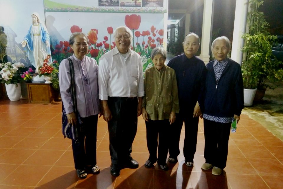 Jesuit Fr. Thomas Vu Quang Trung and Sisters of Providence of Tay Nguyen, Vietnam, pose for a photo at their convent. (Joachim Pham)
