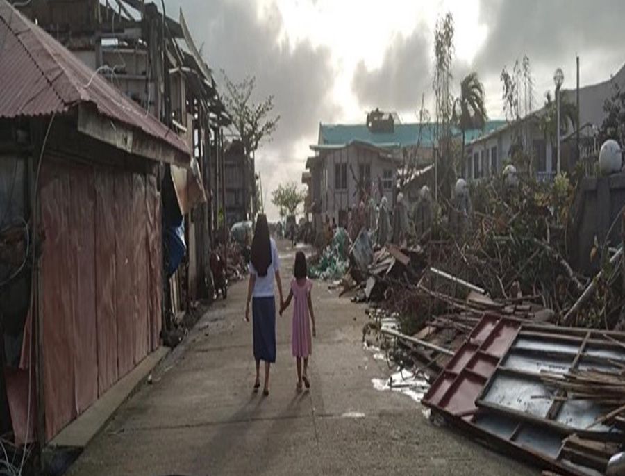 An Missionary Sister of Mary sister walks with her niece to see the aftermath of the typhoon in her hometown in the Dinagat Islands, which were among the worst hit. (Courtesy of Missionary Sisters of Mary) 