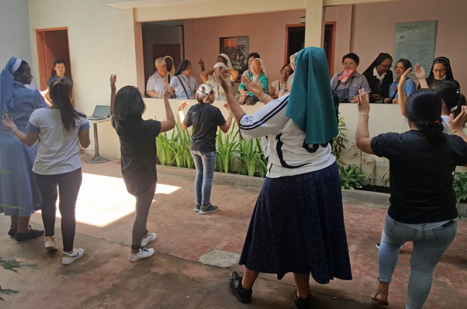 In this 2017 photo, Sr. Letta Mosue, in black skirt, and Sr. Josephine Mpatane, far left, join a dance performance by young women at the Ruhama Center for Women, a residential facility for young women rescued from trafficking and abuse in Manila. (GSR)