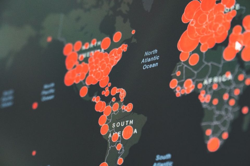 Like a blanket the virus wrapped around the Earth community and forced us to focus on these difficult realities; and as we did, we saw gaping wounds beneath the spread of the virus. (Unsplash/Martin Sanchez) World map showing red circles of coronavirus infections
