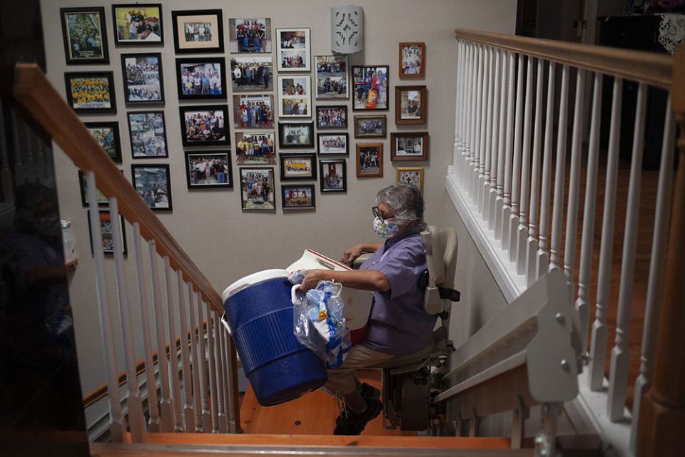 Benedictine Sr. Ursula Herrera uses a stair lift to haul a 5-gallon cooler as she prepares to make lemonade and cook hot dogs for hundreds of Haitians in Ciudad Acuña, Mexico, Sept. 22. (Nuri Vallbona)