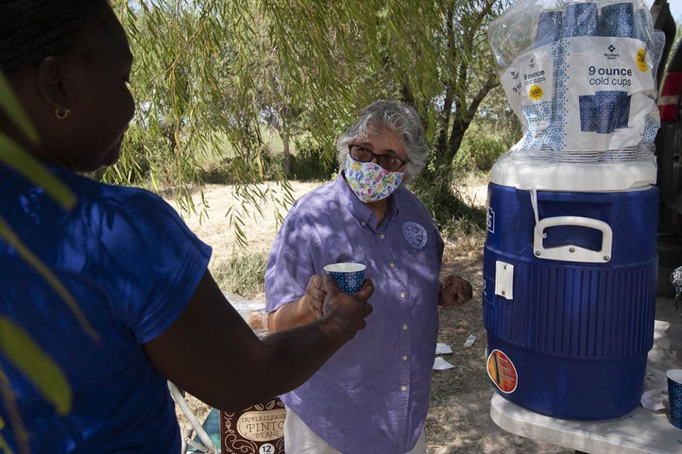 Benedictine Sr. Ursula Herrera helps pass out lemonade to Haitians sheltering in an immigration camp in Ciudad Acuña, Mexico, Sept. 22. (Nuri Vallbona)