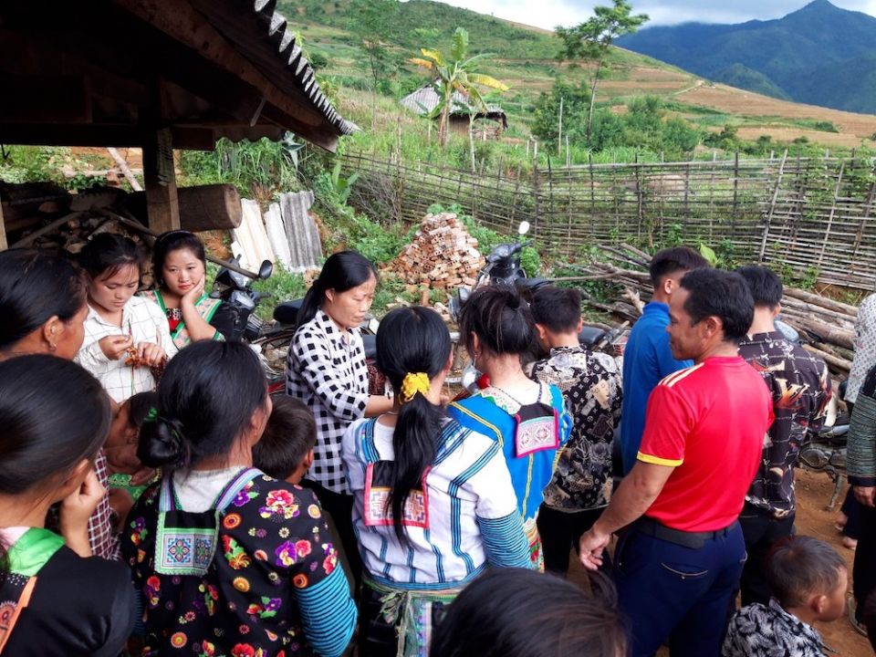 Sr. Mary Do Thi Quyen, center, offers rosaries and candy to Hmong ethnic villagers in June in Lai Chau Province. (Provided photo)