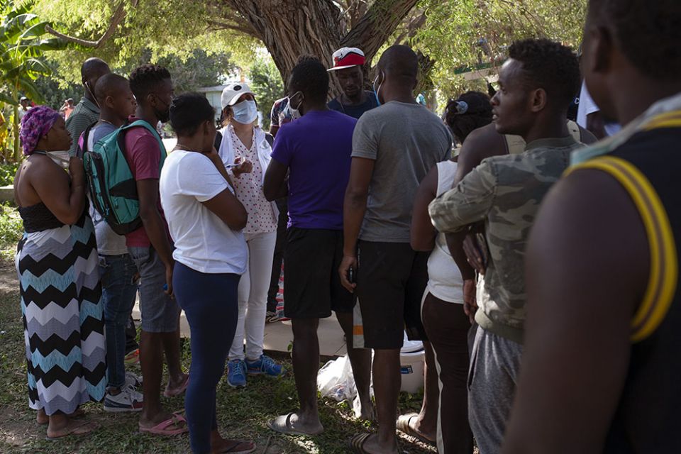 A worker for the Comisión Nacional de los Derechos Humanos, Mexico's National Commission for Human Rights, tries to get a sense of how many Haitians want Mexican work permits at an immigration camp in Ciudad Acuña, Mexico, Sept. 22.