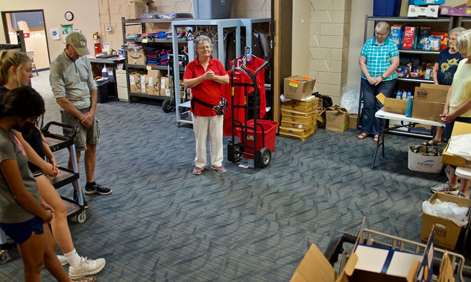Volunteers gather in prayer at the end of a twice-weekly food pantry held at Ministry on the Margins in Bismarck, North Dakota. Leading the prayer is Benedictine Sr. Kathleen Atkinson (in red), the agency's director. (GSR photo/Dan Stockman)