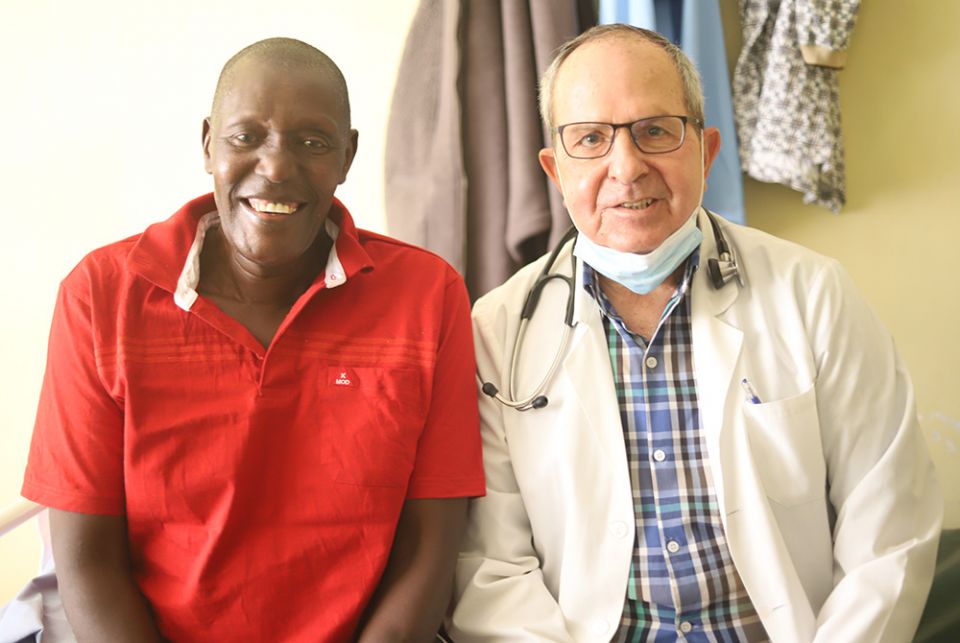 Dr. William Fryda, an American former Maryknoll priest, sits with a patient in the ward after attending to him on June 2 at St. Joseph Hospital in Gilgil. Fryda now runs the new heath facility which he opened after the fallout with the Assumption Sisters 