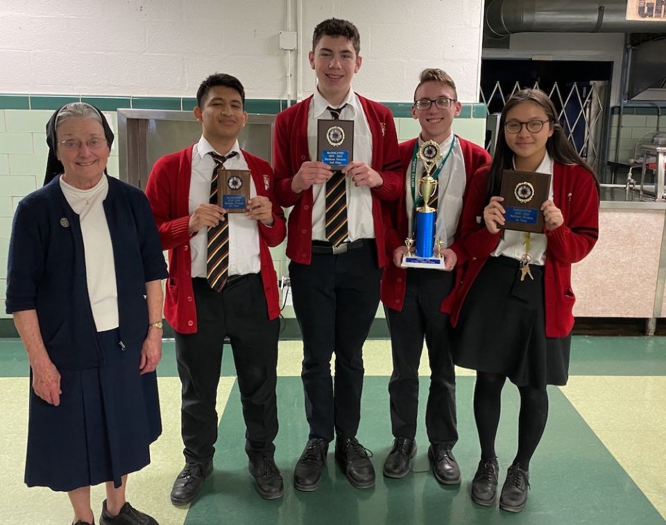 Coach Sr. Alice Hess stands in the school cafeteria next to the students who scored the highest in the 2019 Mathlete competition in the Philadelphia Archdiocese. The Archbishop Ryan High School students are, from left, Matthias Davila, Gabriel Charpentier