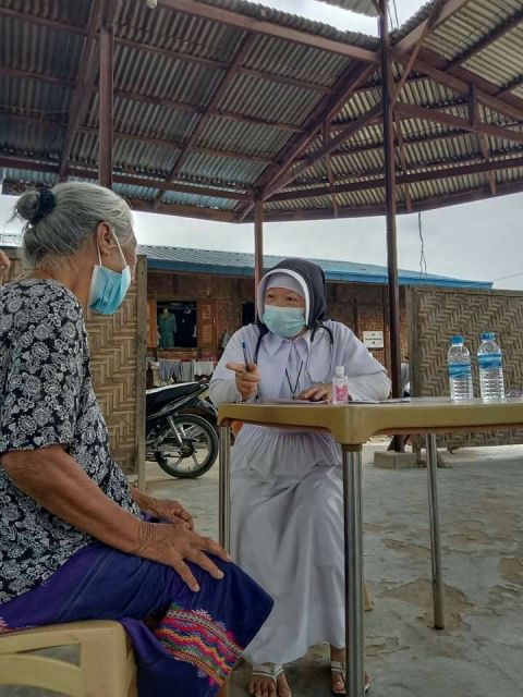 Sister Ann helps an elder in the Myanmar clinic. (Courtesy of Sr. Ann Nu Tawng)